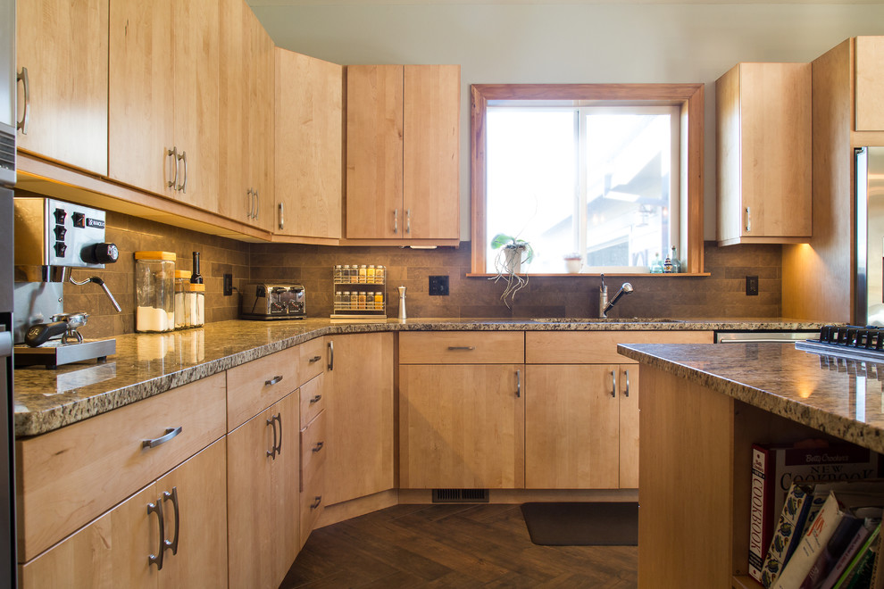 Medium sized rustic l-shaped kitchen/diner in Portland with a submerged sink, flat-panel cabinets, light wood cabinets, granite worktops, brown splashback, stone tiled splashback, stainless steel appliances, an island and porcelain flooring.