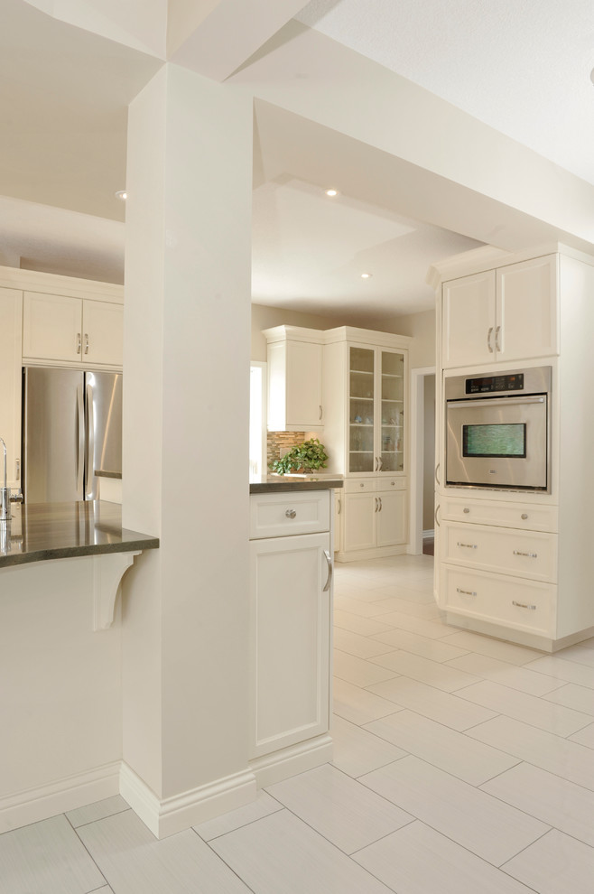 Photo of a large traditional kitchen in Toronto with a double-bowl sink, shaker cabinets, white cabinets, granite worktops, multi-coloured splashback, matchstick tiled splashback, stainless steel appliances, porcelain flooring and an island.