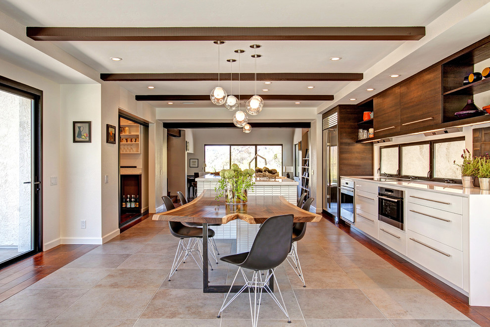 Zweizeilige Moderne Wohnküche mit flächenbündigen Schrankfronten, weißen Schränken, Küchengeräten aus Edelstahl, Kücheninsel und beigem Boden in San Diego