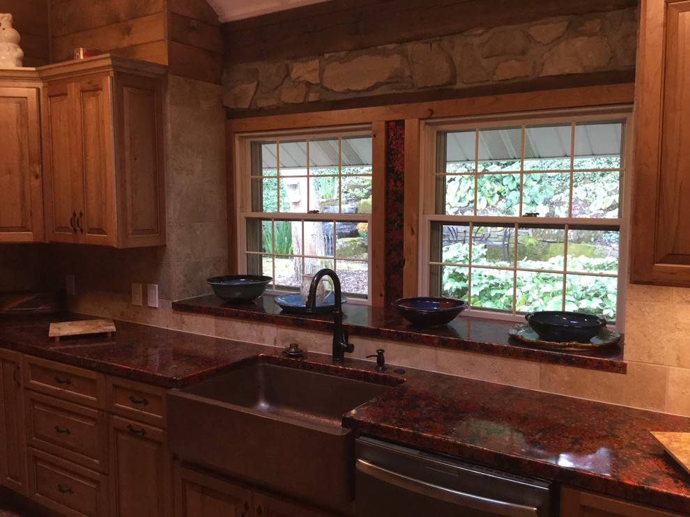 Exempel på ett mellanstort lantligt kök, med en rustik diskho, luckor med upphöjd panel, skåp i mellenmörkt trä, bänkskiva i akrylsten, beige stänkskydd, stänkskydd i stenkakel, rostfria vitvaror, kalkstensgolv och en halv köksö
