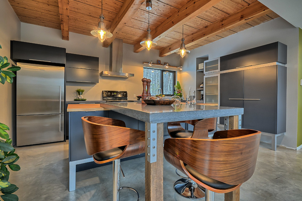 Photo of a medium sized contemporary l-shaped kitchen/diner in Montreal with a submerged sink, flat-panel cabinets, grey cabinets, concrete worktops, stainless steel appliances, concrete flooring and an island.