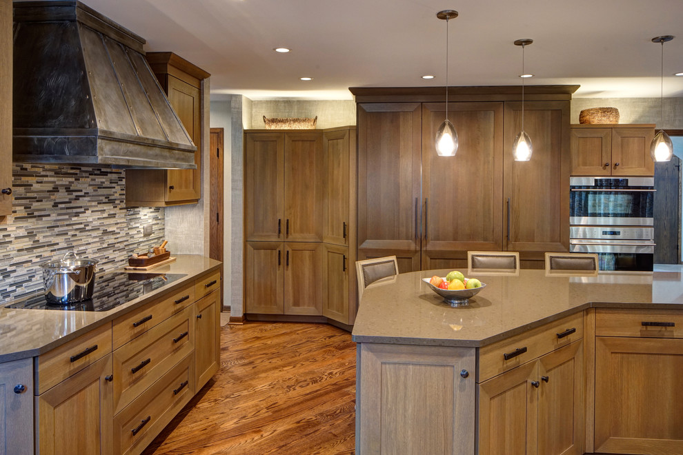 Transitional medium tone wood floor eat-in kitchen photo in Chicago with a double-bowl sink, shaker cabinets, medium tone wood cabinets, quartz countertops, gray backsplash, stone tile backsplash, stainless steel appliances and an island