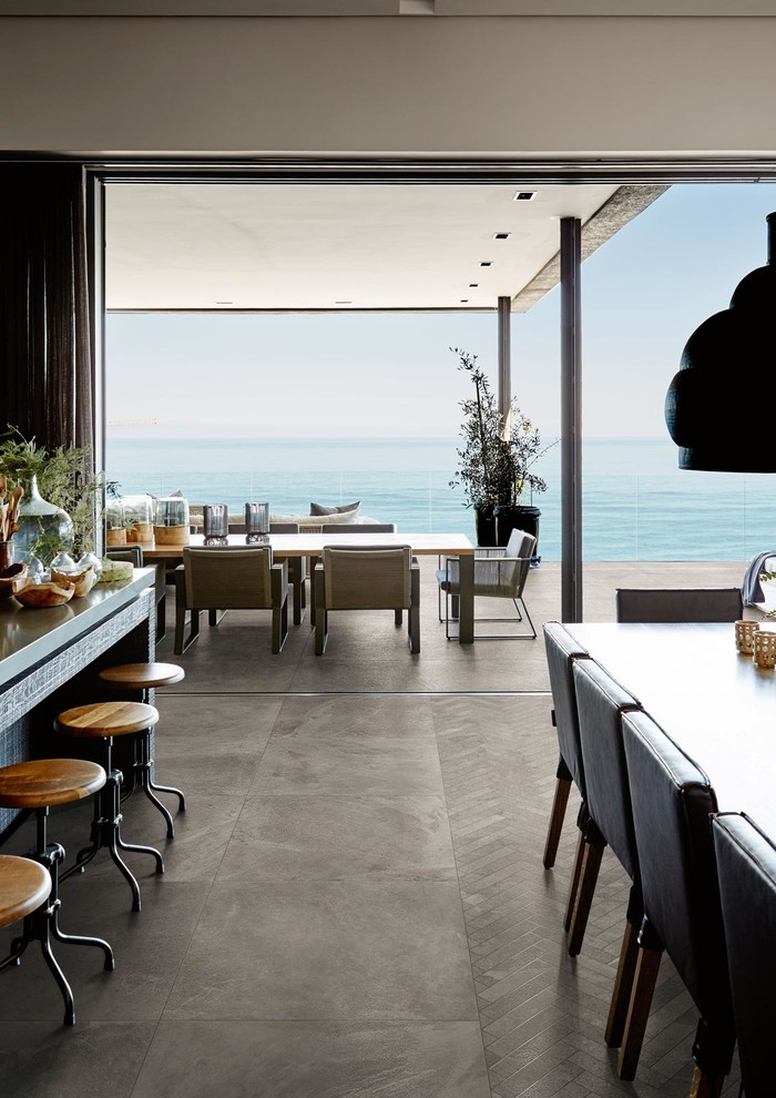Immagine di una cucina contemporanea con top in vetro, pavimento in gres porcellanato, 2 o più isole e pavimento marrone
