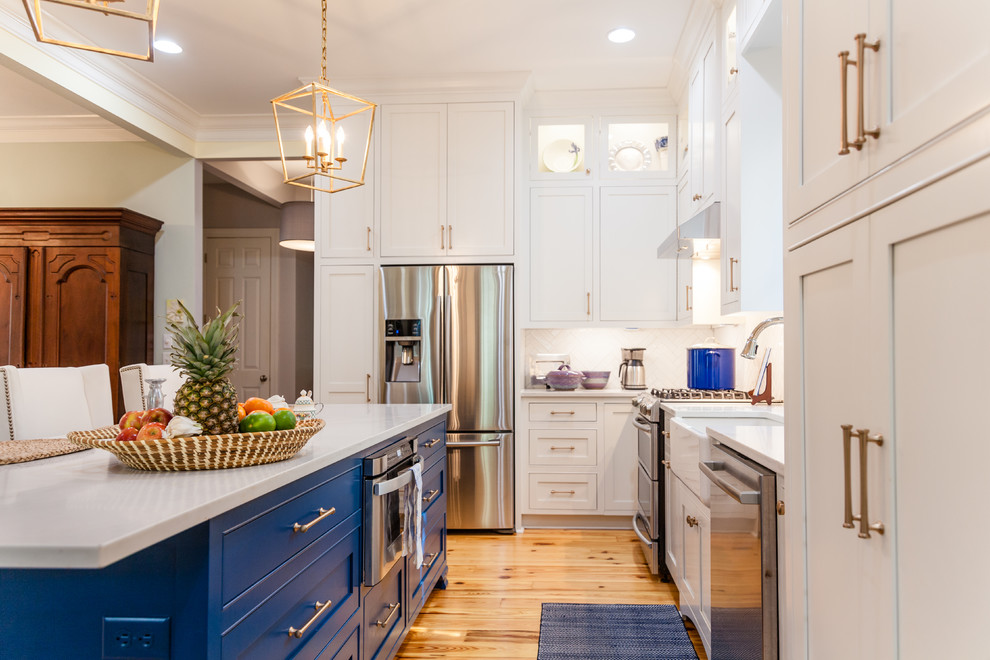 Open concept kitchen - large transitional l-shaped medium tone wood floor open concept kitchen idea in Charleston with a farmhouse sink, beaded inset cabinets, blue cabinets, quartz countertops, white backsplash, subway tile backsplash, stainless steel appliances and an island