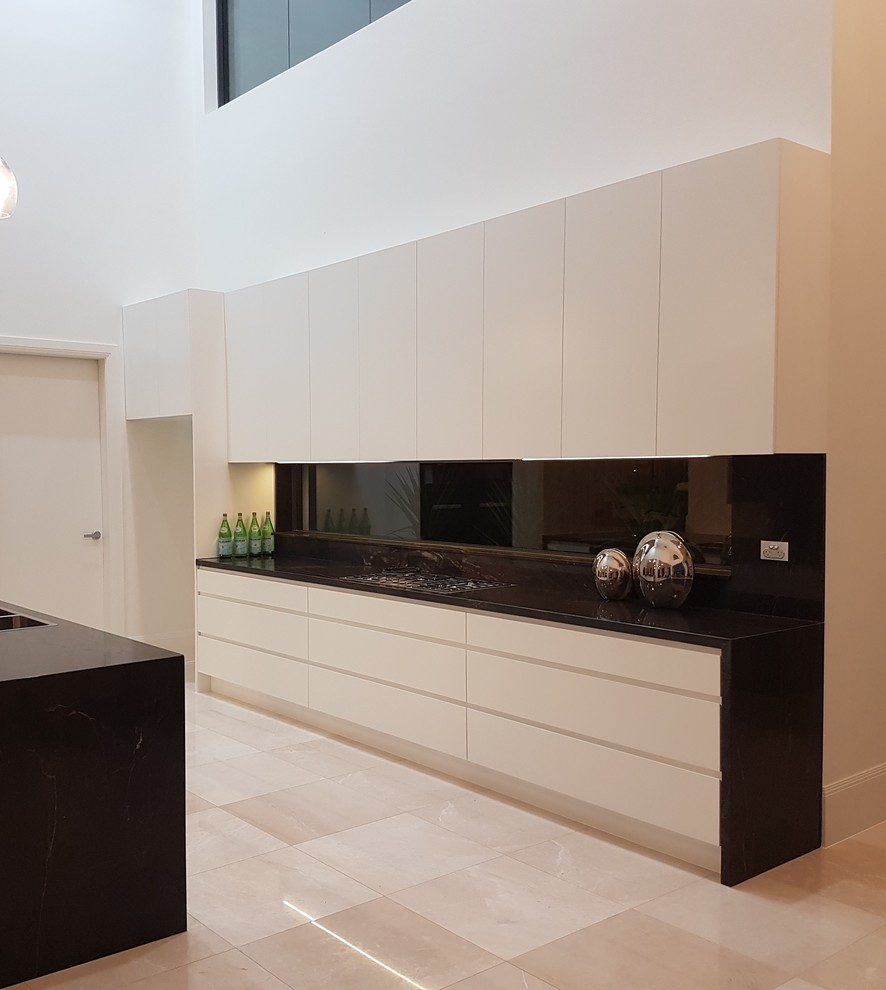 Inspiration for a large modern galley kitchen/diner in Sydney with a double-bowl sink, recessed-panel cabinets, white cabinets, quartz worktops, brown splashback, glass sheet splashback, stainless steel appliances, marble flooring and an island.