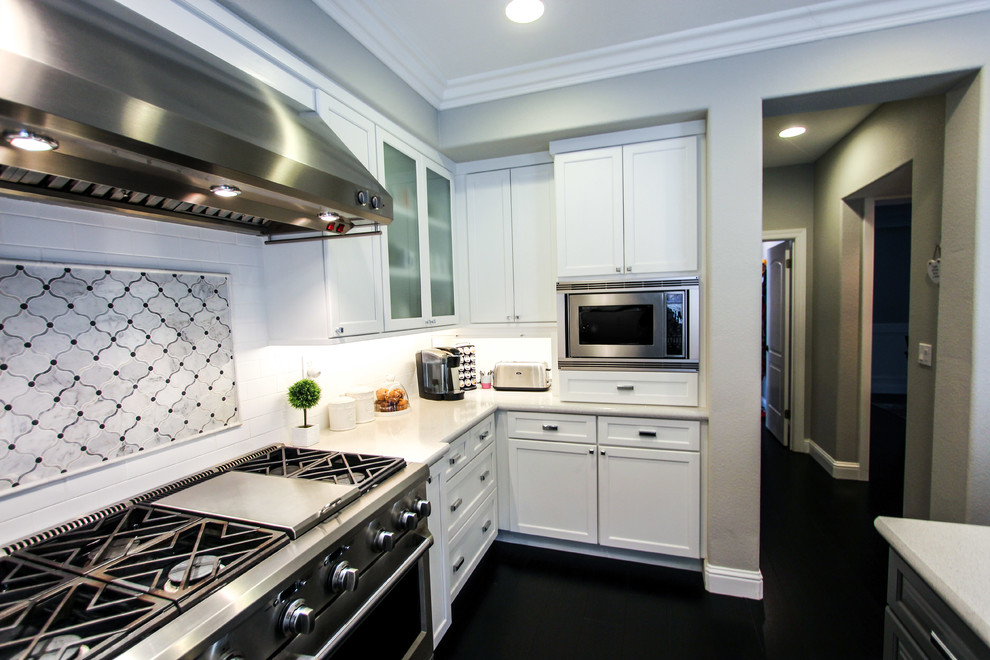 Exempel på ett stort klassiskt kök, med en rustik diskho, luckor med infälld panel, vita skåp, bänkskiva i kvarts, vitt stänkskydd, stänkskydd i porslinskakel, rostfria vitvaror, mörkt trägolv och en köksö