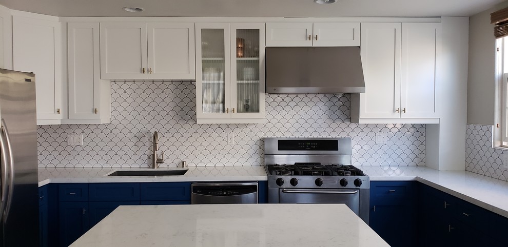 Mid-sized transitional u-shaped cement tile floor and gray floor kitchen photo in San Diego with an undermount sink, shaker cabinets, blue cabinets, quartz countertops, white backsplash, ceramic backsplash, stainless steel appliances, an island and white countertops