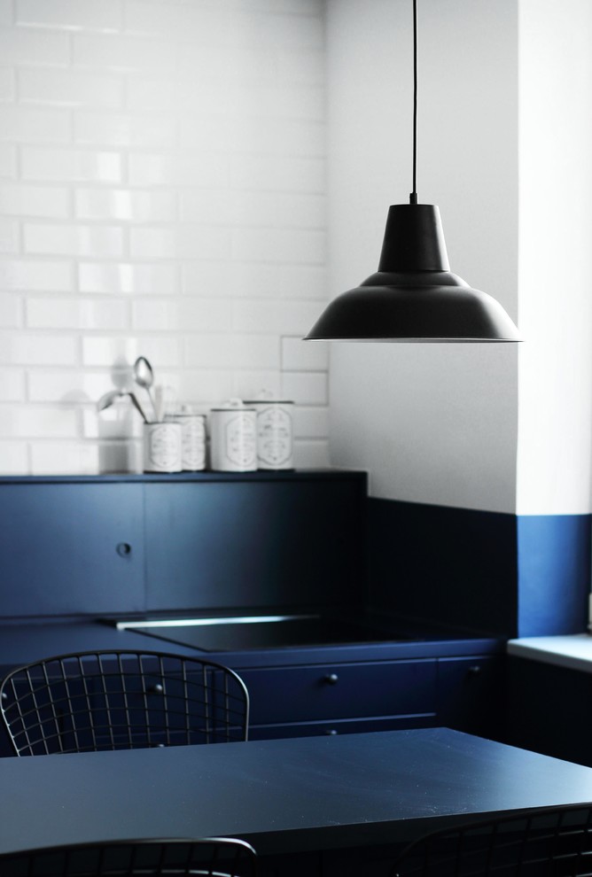 Стильный дизайн: параллельная кухня-гостиная среднего размера в стиле лофт с одинарной мойкой, фасадами с декоративным кантом, синими фасадами, столешницей из ламината, синим фартуком, фартуком из кирпича, черной техникой, полом из керамогранита, островом, синим полом и синей столешницей - последний тренд