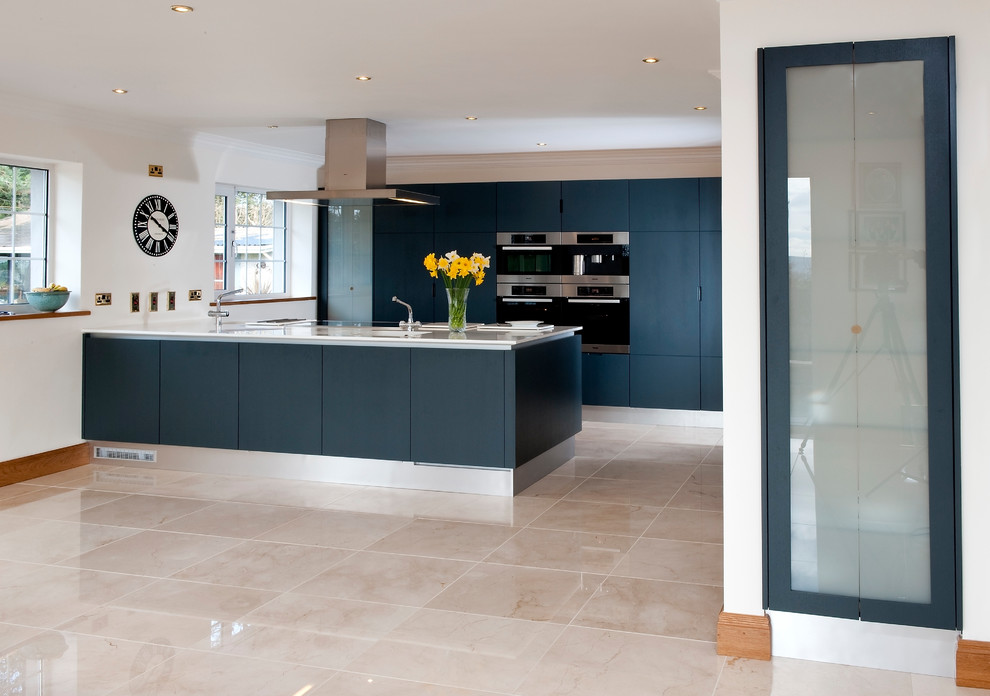 Photo of a contemporary kitchen in Cork with a built-in sink, flat-panel cabinets, blue cabinets, quartz worktops, stainless steel appliances, porcelain flooring, an island, beige floors and white worktops.