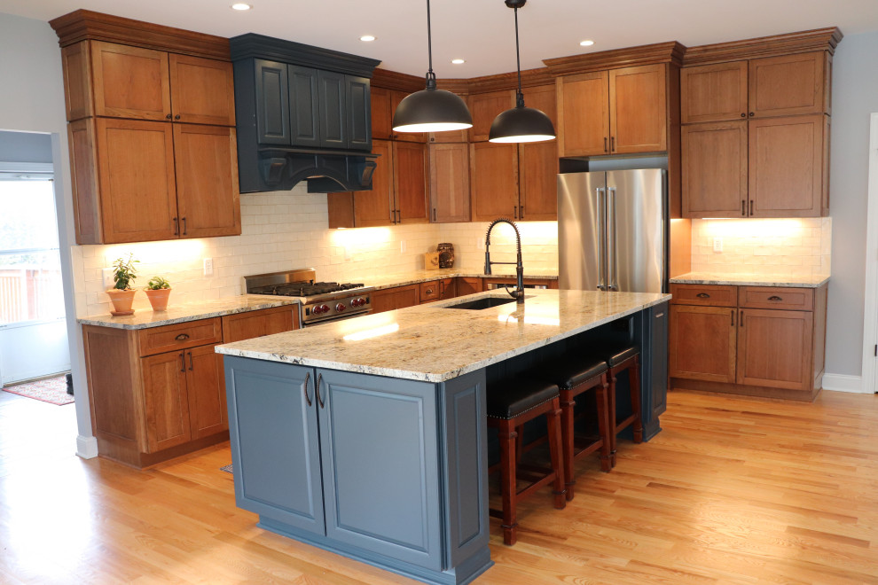 Inspiration for a huge transitional l-shaped light wood floor and yellow floor eat-in kitchen remodel in New York with an undermount sink, shaker cabinets, blue cabinets, granite countertops, white backsplash, ceramic backsplash, stainless steel appliances, an island and gray countertops