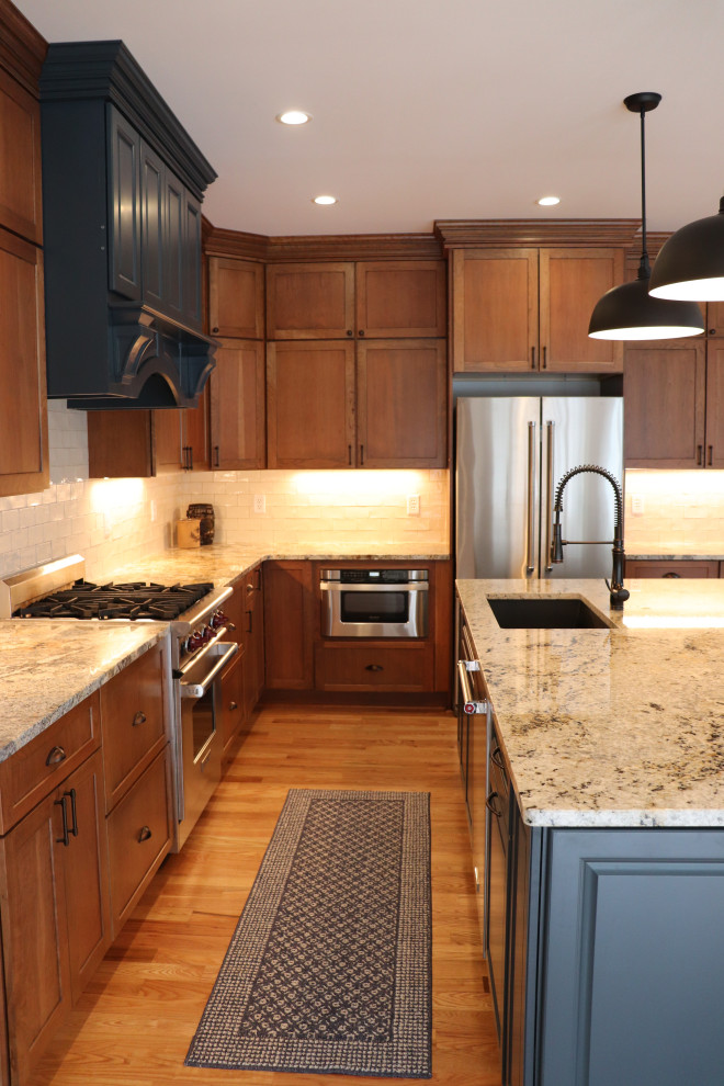 Example of a huge transitional l-shaped light wood floor and yellow floor eat-in kitchen design in New York with an undermount sink, shaker cabinets, blue cabinets, granite countertops, white backsplash, ceramic backsplash, stainless steel appliances, an island and gray countertops
