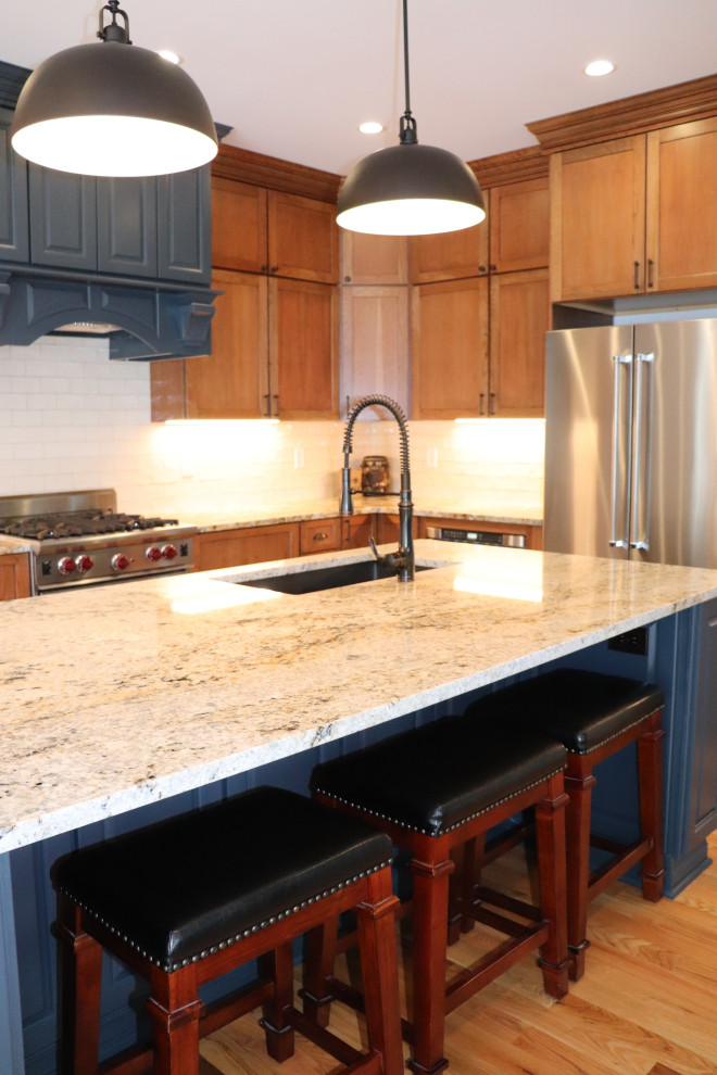 Exempel på ett mycket stort klassiskt grå grått kök, med en undermonterad diskho, skåp i shakerstil, blå skåp, granitbänkskiva, vitt stänkskydd, stänkskydd i keramik, rostfria vitvaror, ljust trägolv, en köksö och gult golv