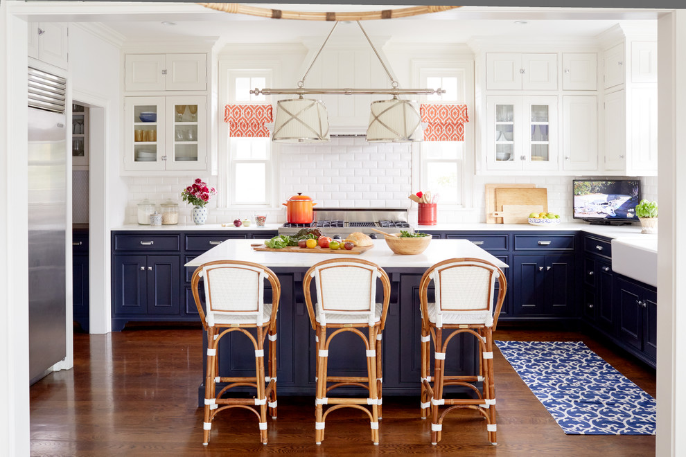 Exempel på ett stort maritimt kök och matrum, med en rustik diskho, luckor med profilerade fronter, blå skåp, marmorbänkskiva, vitt stänkskydd, rostfria vitvaror, en köksö, stänkskydd i tunnelbanekakel och mörkt trägolv