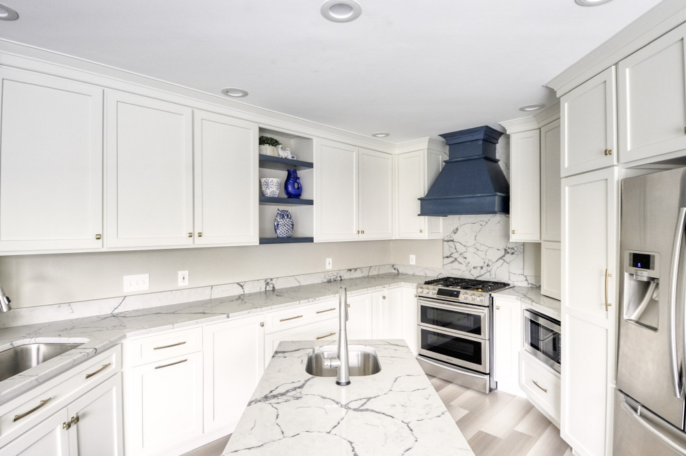 Inspiration for a mid-sized transitional u-shaped laminate floor and gray floor open concept kitchen remodel in DC Metro with an undermount sink, shaker cabinets, white cabinets, quartzite countertops, stainless steel appliances, an island and white countertops