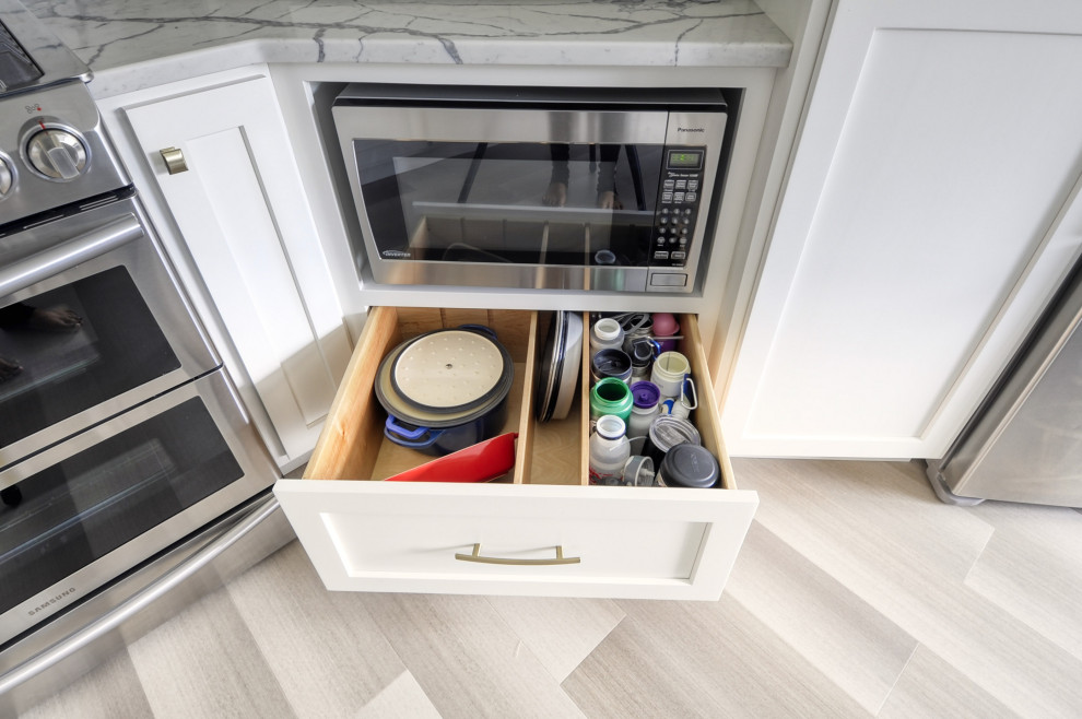 Inspiration for a mid-sized transitional u-shaped laminate floor and gray floor open concept kitchen remodel in DC Metro with an undermount sink, shaker cabinets, white cabinets, quartzite countertops, stainless steel appliances, an island and white countertops