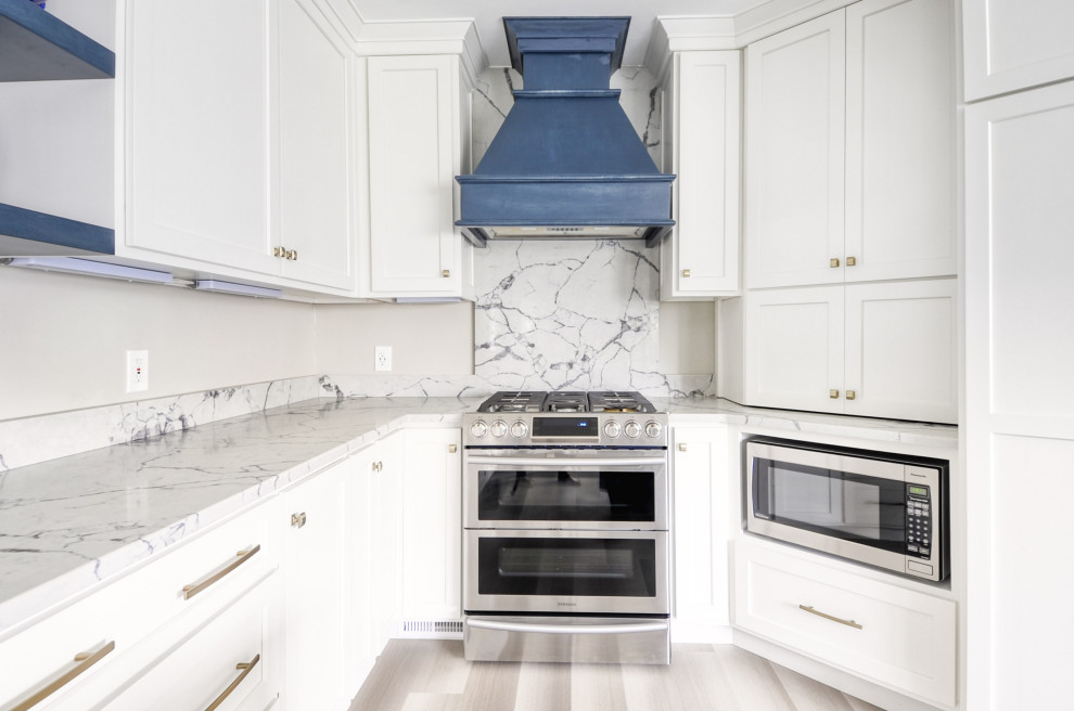 Open concept kitchen - mid-sized transitional u-shaped laminate floor and gray floor open concept kitchen idea in DC Metro with an undermount sink, shaker cabinets, white cabinets, quartzite countertops, stainless steel appliances, an island and white countertops