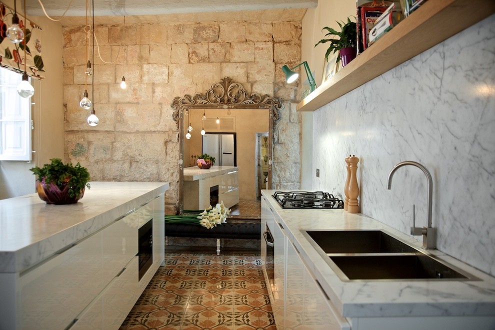 Свежая идея для дизайна: глянцевая кухня среднего размера в стиле фьюжн с полом из керамической плитки, плоскими фасадами, белыми фасадами, белым фартуком и островом - отличное фото интерьера