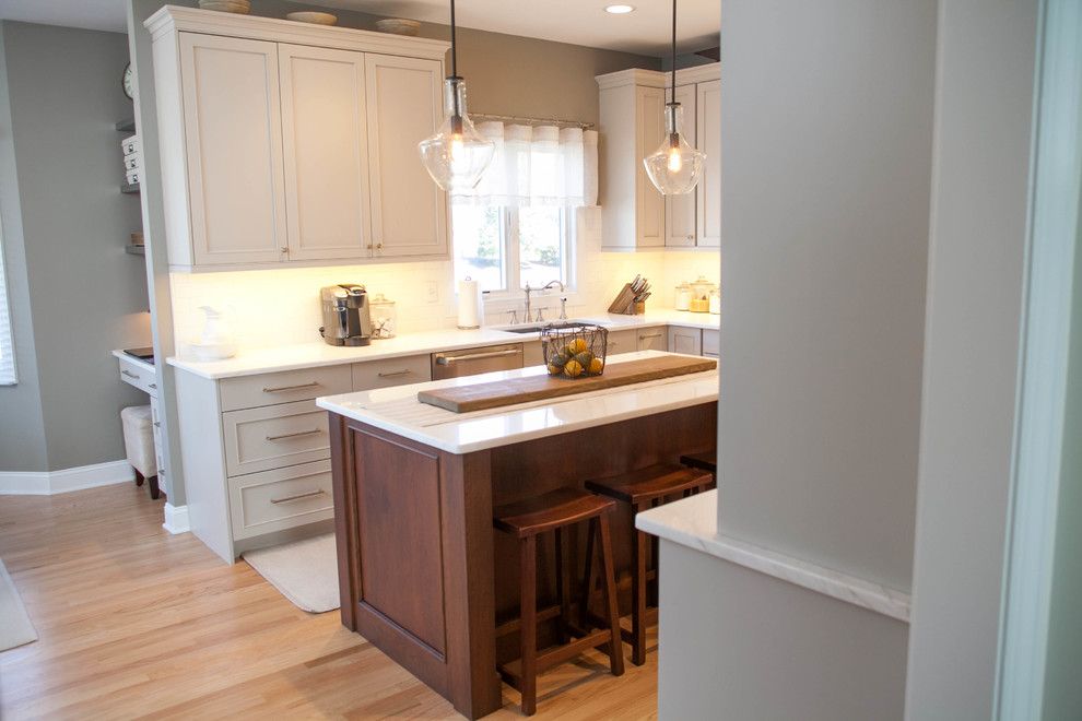 Exempel på ett stort klassiskt kök, med en undermonterad diskho, luckor med infälld panel, grå skåp, marmorbänkskiva, vitt stänkskydd, stänkskydd i tunnelbanekakel, rostfria vitvaror, ljust trägolv och en köksö