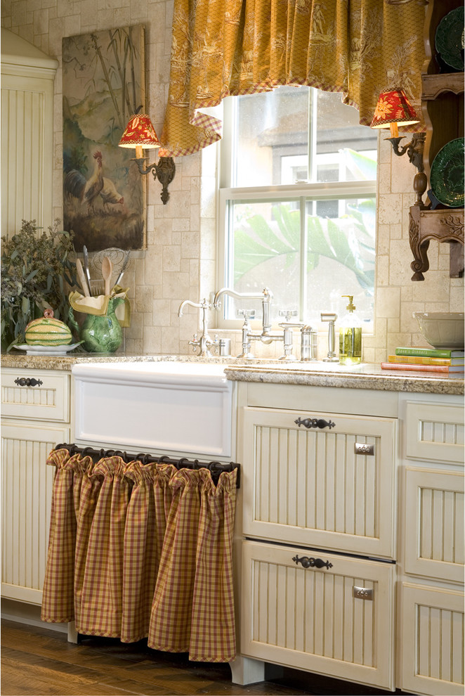 Foto på ett lantligt kök, med en rustik diskho, luckor med infälld panel och beige skåp