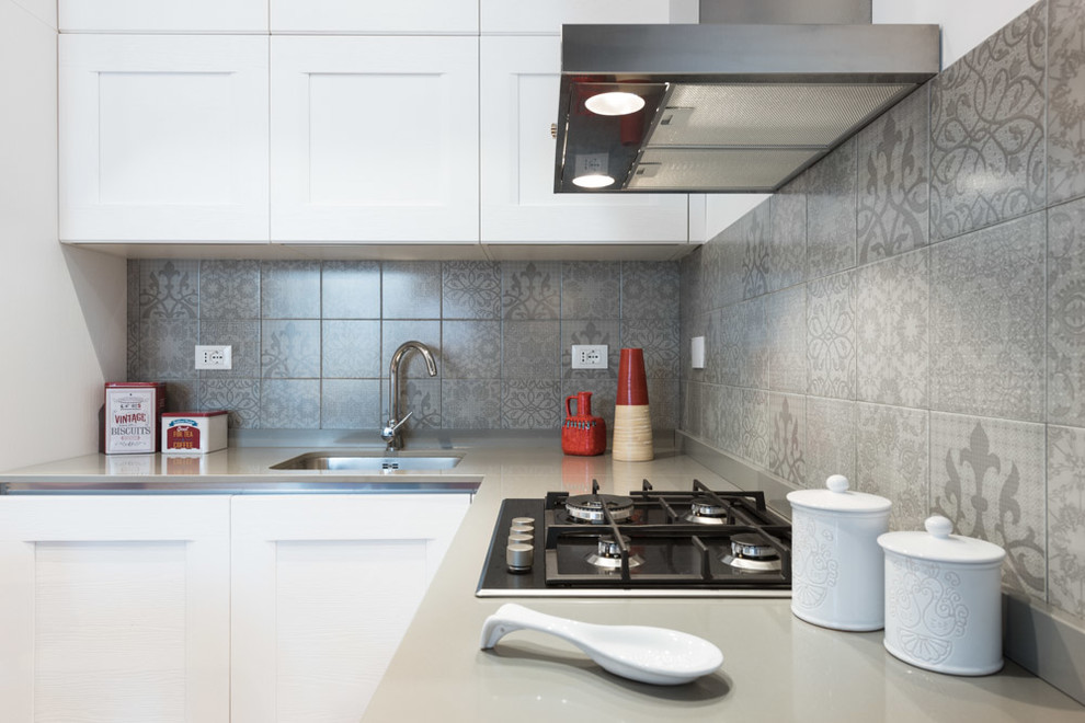 Imagen de cocinas en L minimalista abierta sin isla con fregadero de un seno, salpicadero de azulejos de cerámica y suelo de madera clara