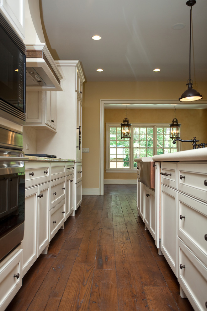 Example of a large classic galley dark wood floor eat-in kitchen design in Chicago with a single-bowl sink, recessed-panel cabinets, white cabinets, granite countertops, white backsplash, ceramic backsplash, paneled appliances and an island