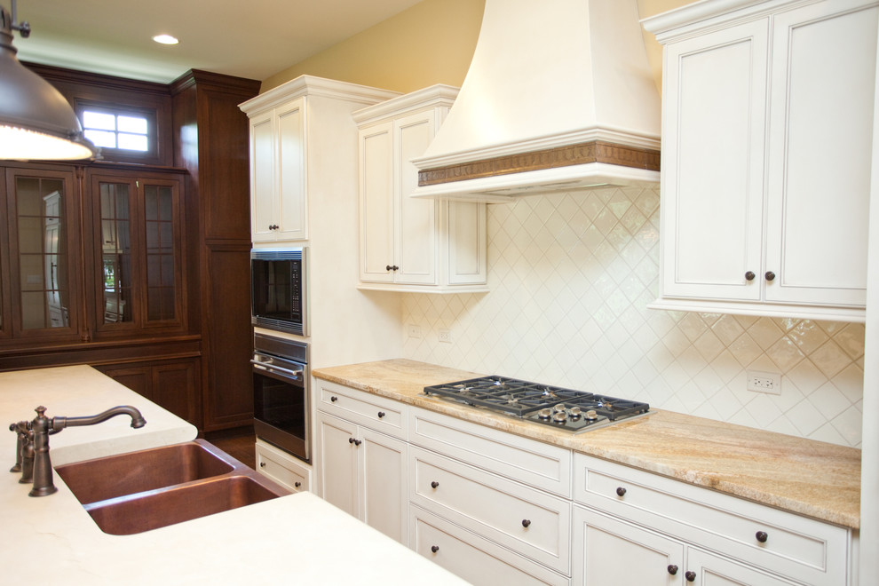 Exempel på ett stort klassiskt kök, med en enkel diskho, luckor med infälld panel, vita skåp, granitbänkskiva, vitt stänkskydd, stänkskydd i keramik, integrerade vitvaror, mörkt trägolv och en köksö