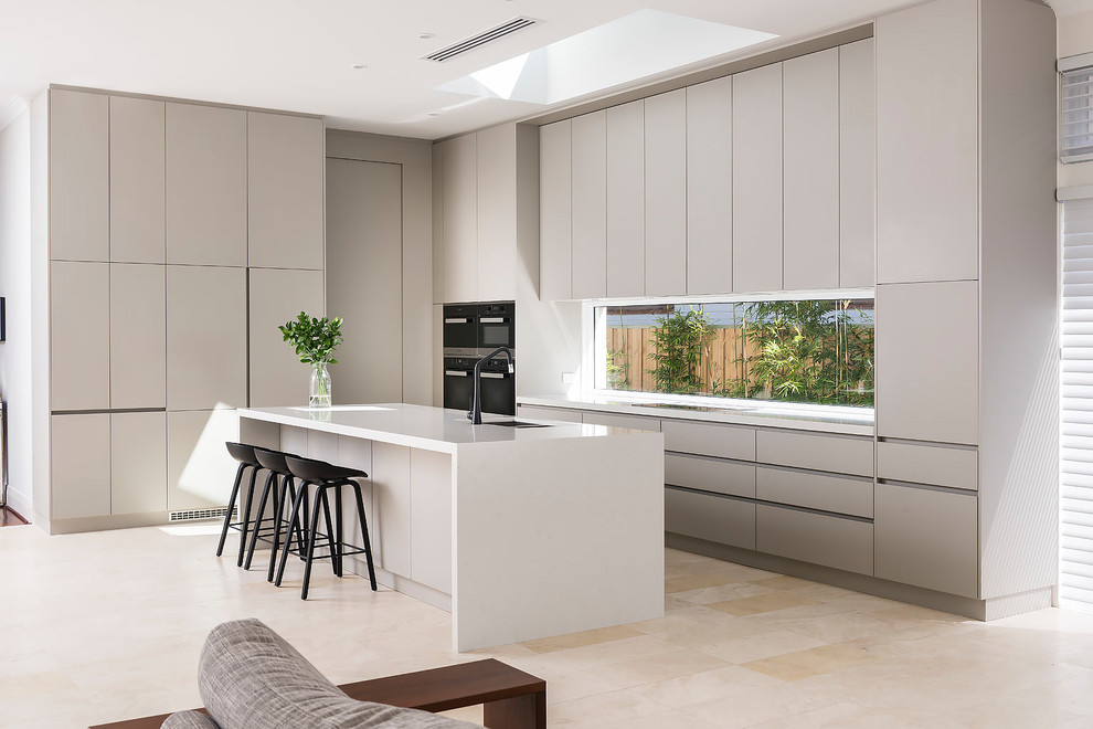 Inspiration for a large contemporary galley open plan kitchen in Perth with a submerged sink, grey cabinets, engineered stone countertops, window splashback, stainless steel appliances, travertine flooring, an island and beige floors.