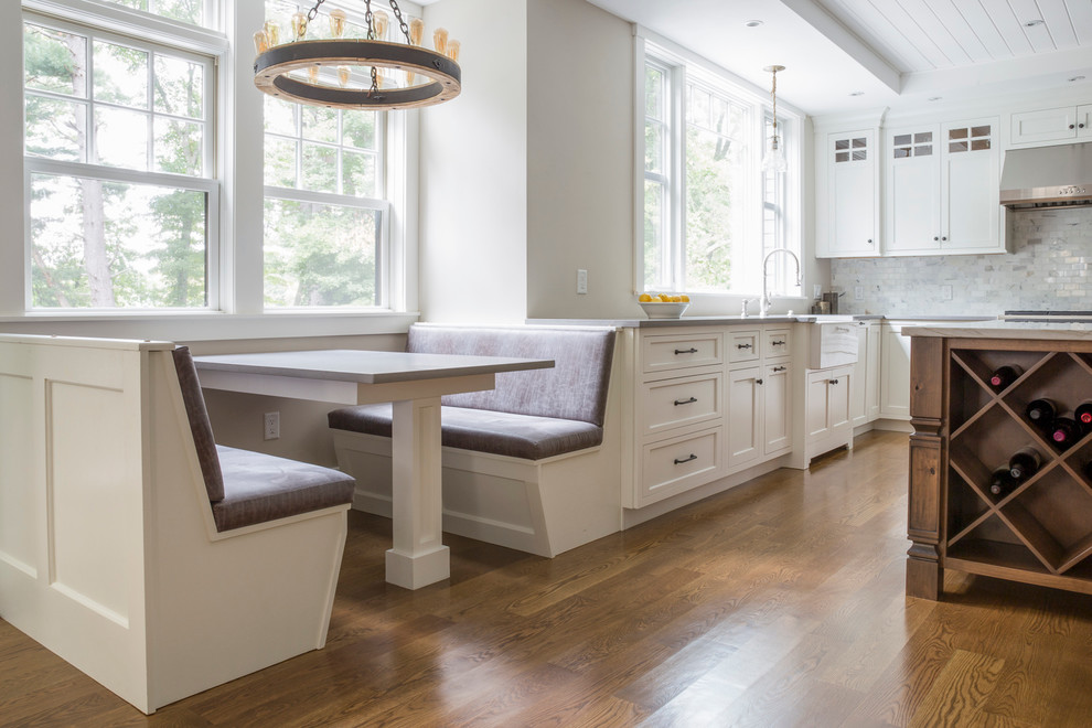 Eat-in kitchen - large country u-shaped light wood floor eat-in kitchen idea in Other with shaker cabinets, white cabinets, quartz countertops, white backsplash, marble backsplash, an island, gray countertops and a farmhouse sink