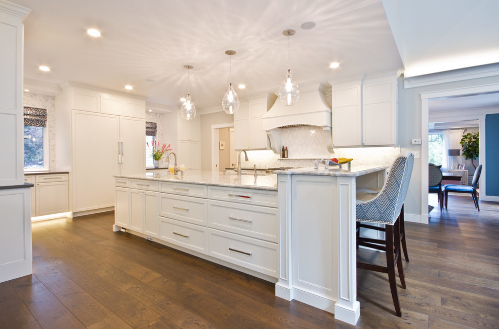Klassische Wohnküche mit Waschbecken, Marmor-Arbeitsplatte, Rückwand aus Steinfliesen, Küchengeräten aus Edelstahl, braunem Holzboden und Kücheninsel in Boston