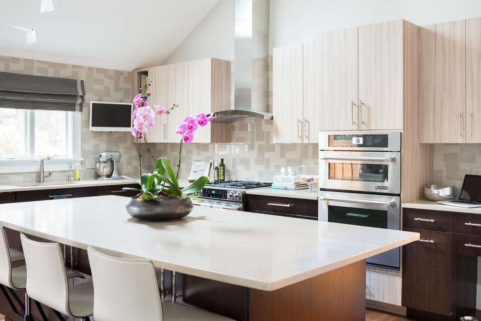 Mid-sized trendy l-shaped eat-in kitchen photo in Boston with an undermount sink, flat-panel cabinets, light wood cabinets, quartzite countertops, multicolored backsplash, porcelain backsplash, stainless steel appliances and an island