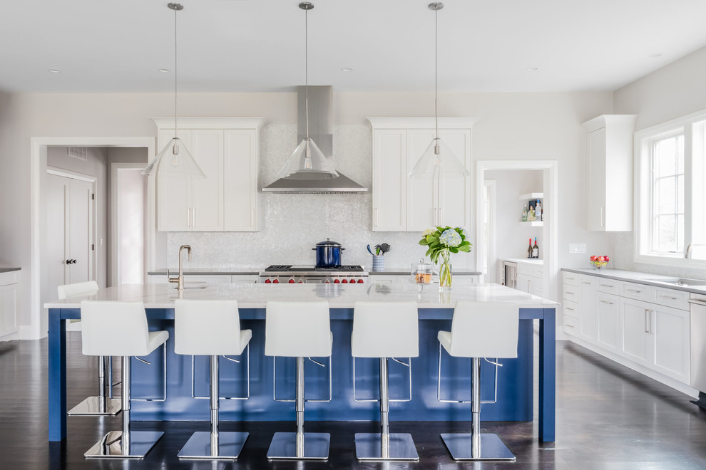 Example of a large transitional l-shaped dark wood floor and brown floor open concept kitchen design in Boston with an undermount sink, shaker cabinets, white cabinets, quartz countertops, white backsplash, marble backsplash, stainless steel appliances, an island and white countertops