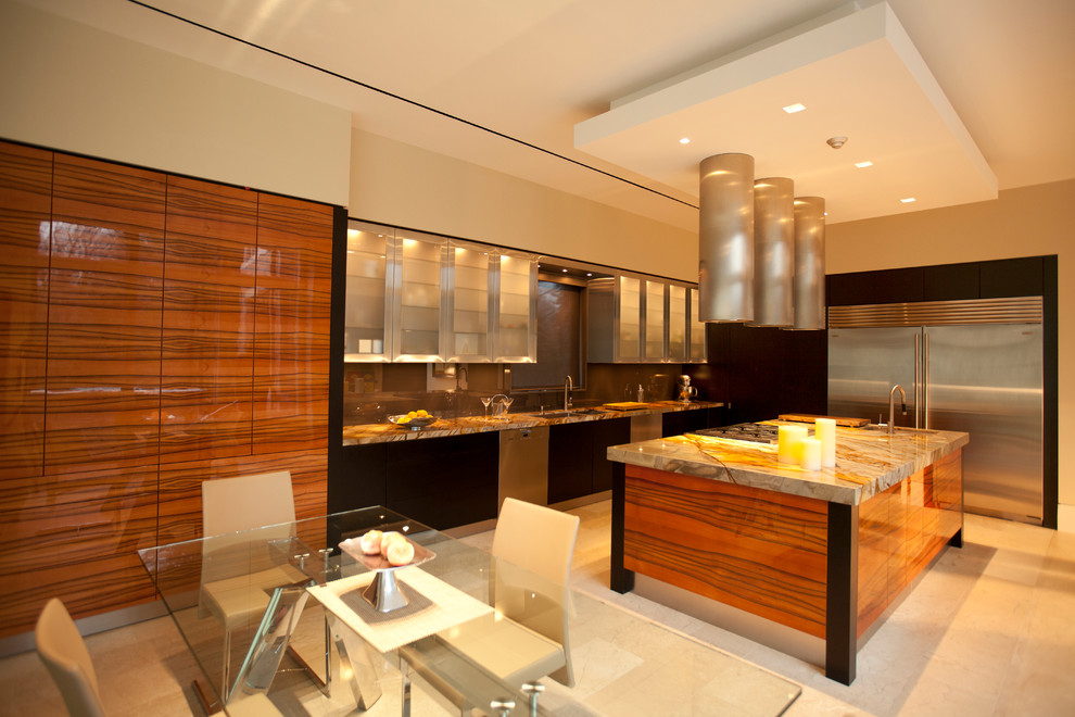 Foto på ett stort kök, med en dubbel diskho, luckor med glaspanel, skåp i rostfritt stål, marmorbänkskiva, rostfria vitvaror, travertin golv och en köksö