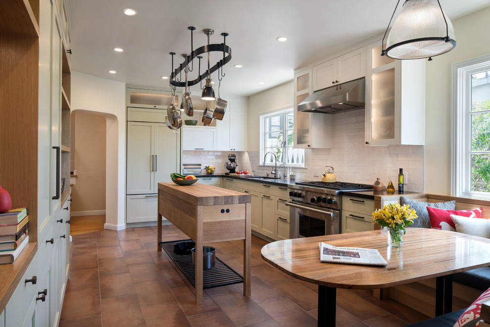 Idéer för att renovera ett avskilt, mellanstort funkis svart linjärt svart kök, med en undermonterad diskho, skåp i shakerstil, gröna skåp, marmorbänkskiva, vitt stänkskydd, stänkskydd i keramik, rostfria vitvaror, klinkergolv i keramik, en köksö och brunt golv