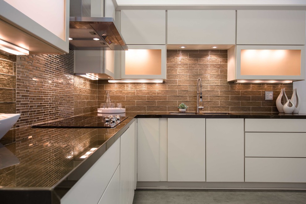 Example of a trendy l-shaped concrete floor and gray floor kitchen design in Richmond with an undermount sink, flat-panel cabinets, white cabinets, solid surface countertops, gray backsplash, glass tile backsplash and stainless steel appliances
