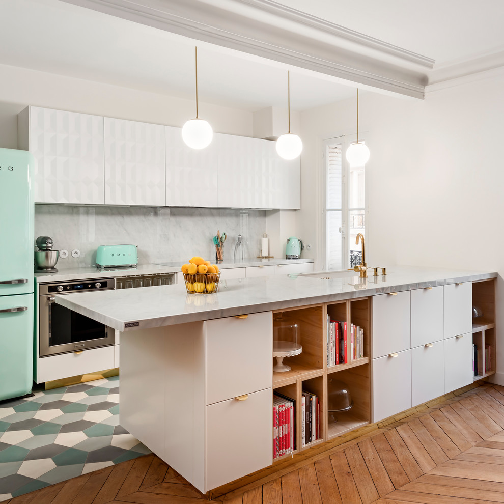Zweizeilige Moderne Küche mit flächenbündigen Schrankfronten, weißen Schränken, Küchenrückwand in Grau, Rückwand aus Marmor, bunten Elektrogeräten, Halbinsel und buntem Boden in Essex