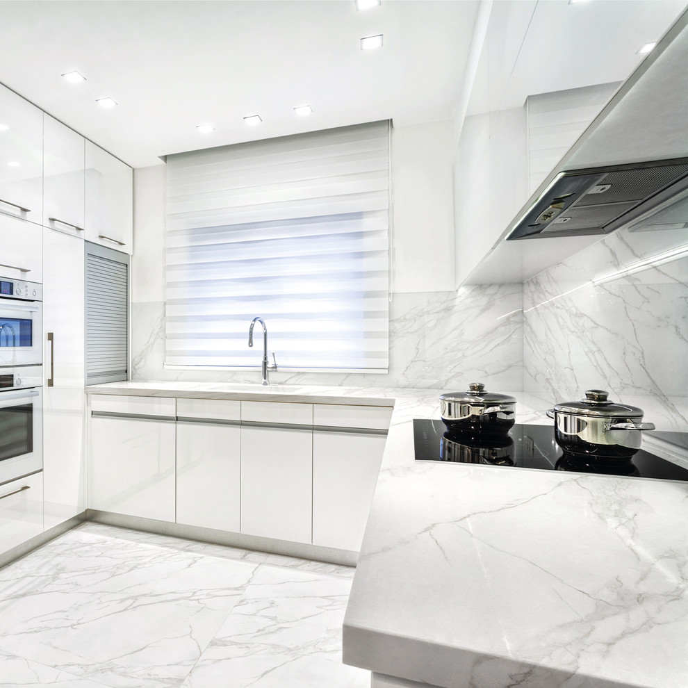 Idéer för avskilda funkis u-kök, med en nedsänkt diskho, släta luckor, vita skåp, marmorbänkskiva, vitt stänkskydd, stänkskydd i marmor, vita vitvaror, marmorgolv och vitt golv