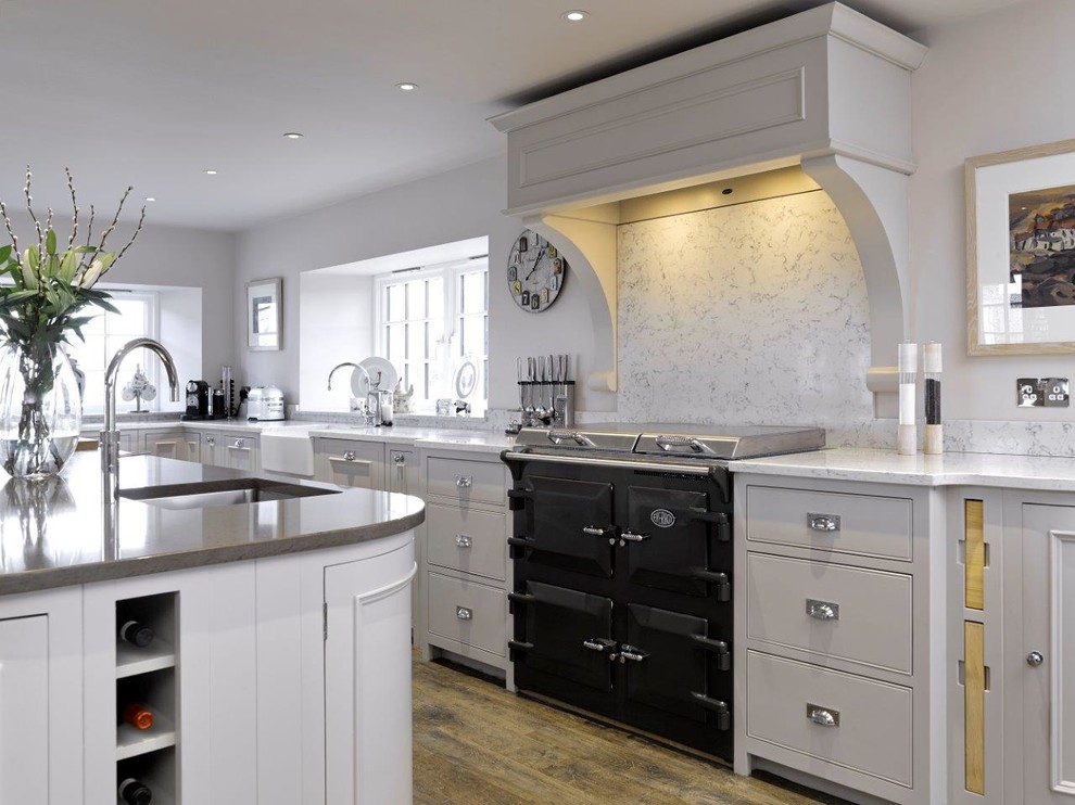 Medium sized classic l-shaped kitchen/diner in Other with a belfast sink, beaded cabinets, white cabinets, quartz worktops, white splashback, coloured appliances, travertine flooring and an island.