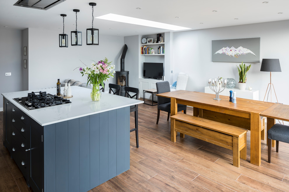 Medium sized victorian single-wall kitchen/diner in London with a belfast sink, shaker cabinets, quartz worktops and an island.