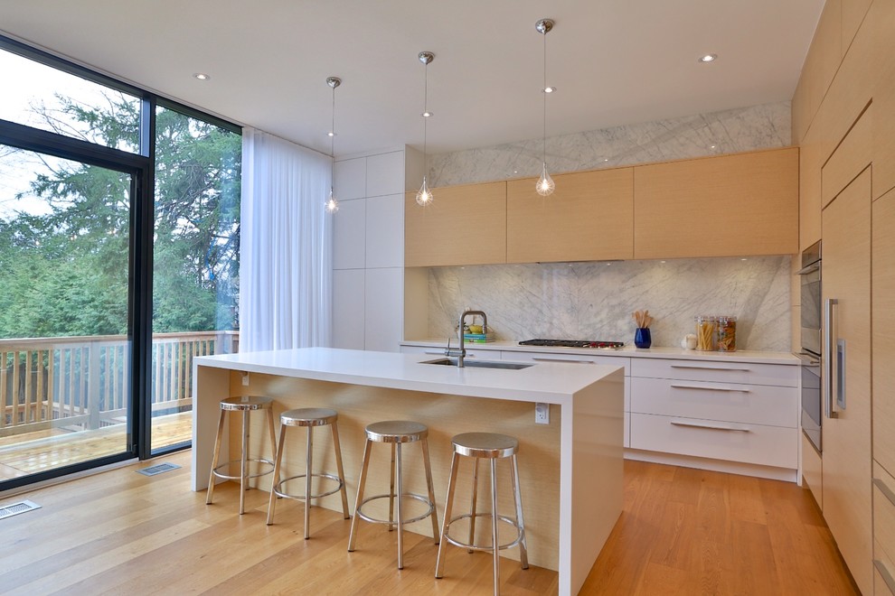 Bild på ett mellanstort funkis vit vitt kök, med en undermonterad diskho, släta luckor, skåp i ljust trä, bänkskiva i kvarts, vitt stänkskydd, stänkskydd i sten, rostfria vitvaror, ljust trägolv, en köksö och gult golv