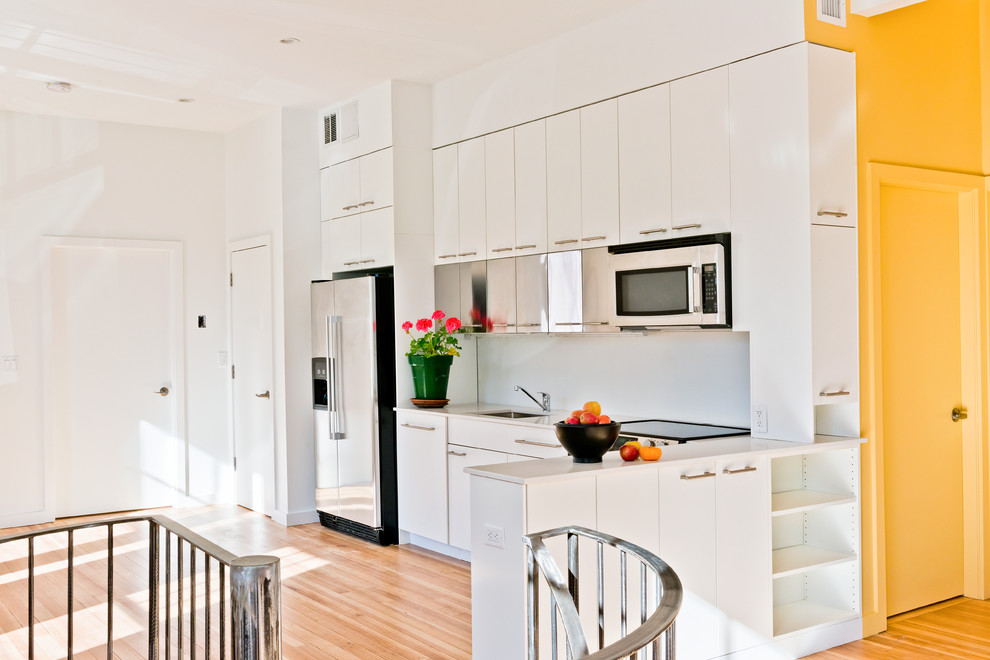 Medium sized contemporary single-wall kitchen/diner in Boston with a single-bowl sink, white cabinets, light hardwood flooring and no island.