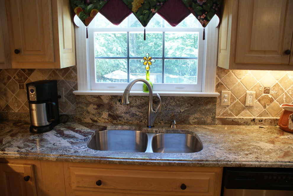 Foto de cocina contemporánea con fregadero bajoencimera, puertas de armario blancas, encimera de granito, suelo de madera clara y una isla