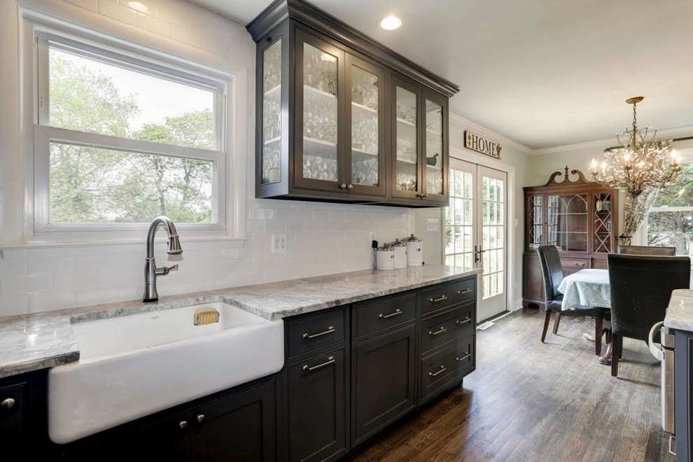 Small transitional u-shaped medium tone wood floor open concept kitchen photo in Baltimore with a farmhouse sink, shaker cabinets, gray cabinets, marble countertops, white backsplash, subway tile backsplash, stainless steel appliances and a peninsula