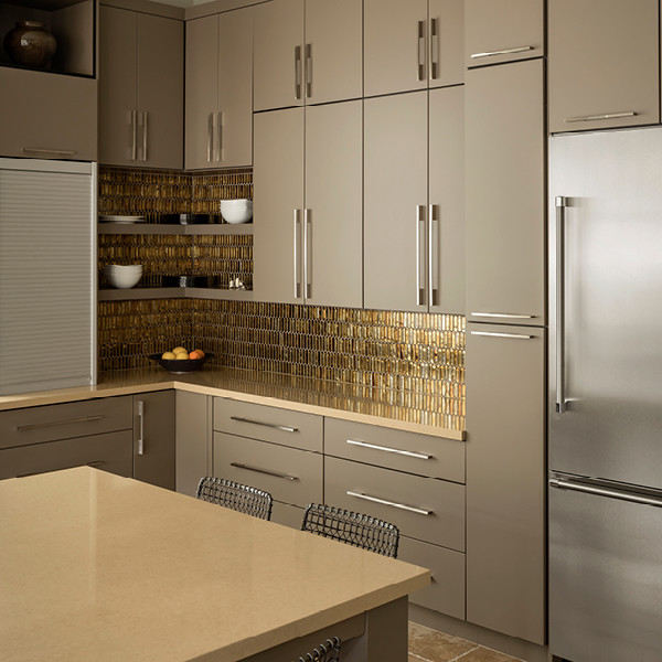 Modern kitchen in Minneapolis with metallic splashback and glass tiled splashback.