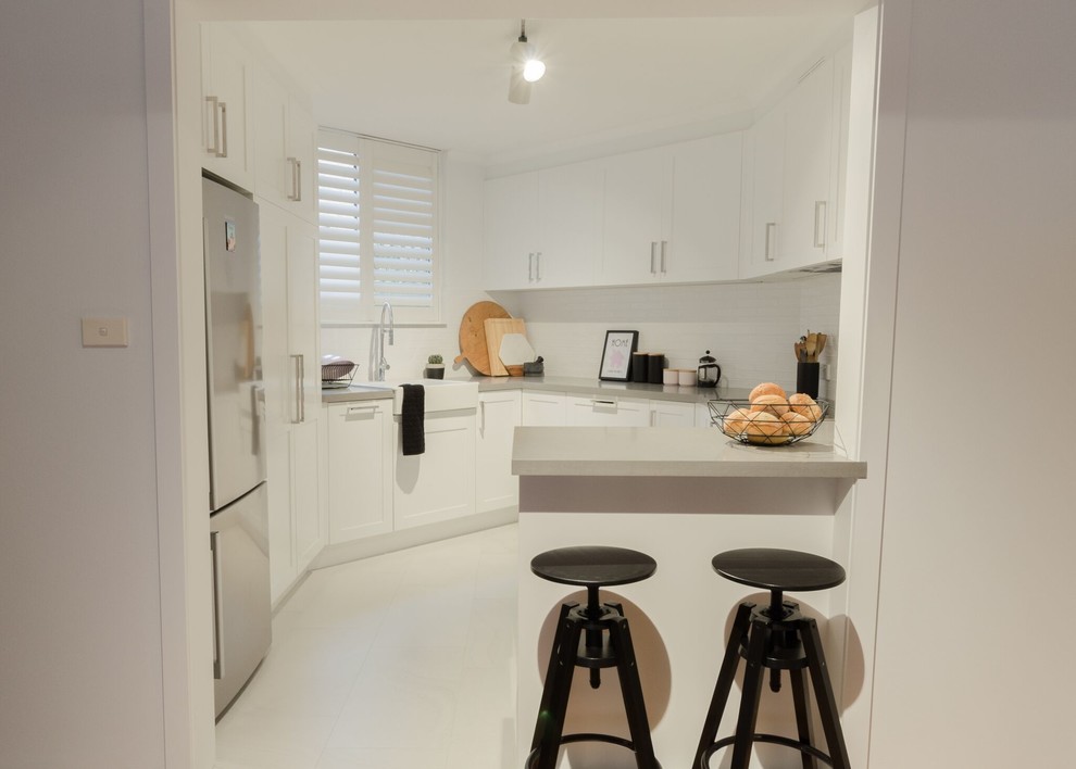 Foto di una cucina minimal con ante in stile shaker e ante bianche