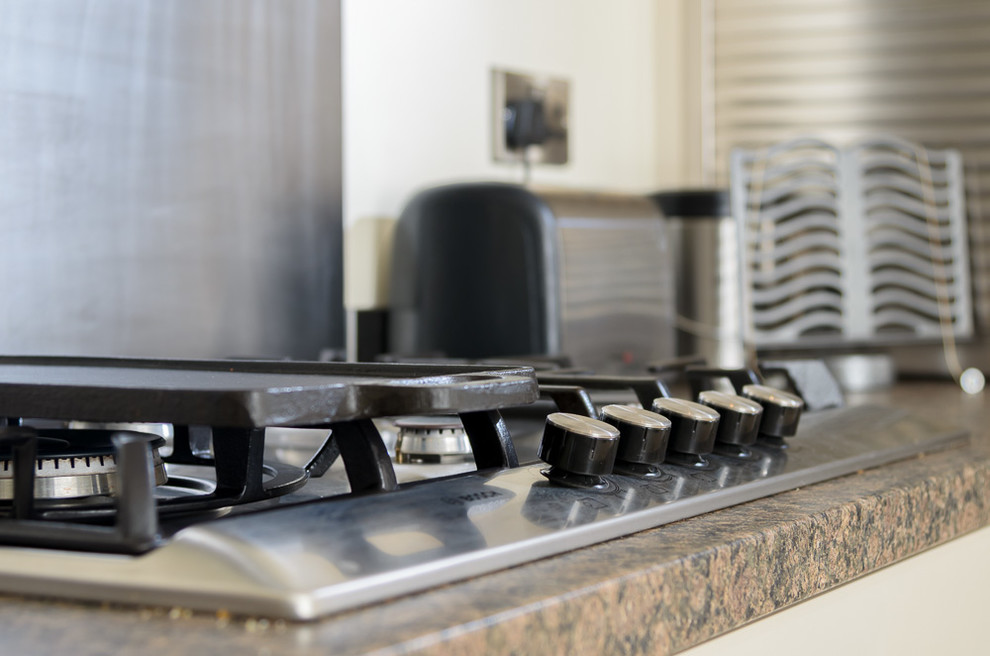 Foto di una piccola cucina moderna con ante lisce, paraspruzzi a effetto metallico, elettrodomestici da incasso, pavimento in marmo e nessuna isola