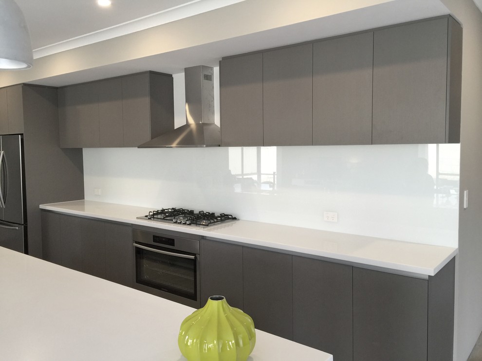 Zweizeilige, Mittelgroße Moderne Wohnküche mit Triple-Waschtisch, profilierten Schrankfronten, hellbraunen Holzschränken, Quarzwerkstein-Arbeitsplatte, Küchenrückwand in Weiß, Glasrückwand, Küchengeräten aus Edelstahl und Kücheninsel in Perth