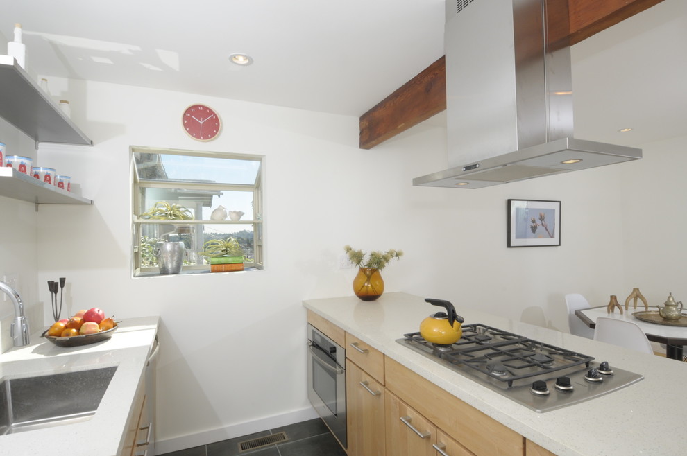 Immagine di una cucina contemporanea con lavello sottopiano, ante lisce e ante in legno chiaro