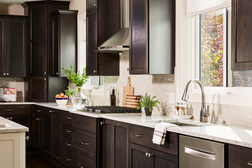 Example of a large classic l-shaped dark wood floor and brown floor eat-in kitchen design in Minneapolis with an undermount sink, recessed-panel cabinets, dark wood cabinets, granite countertops, white backsplash, subway tile backsplash, stainless steel appliances, an island and white countertops