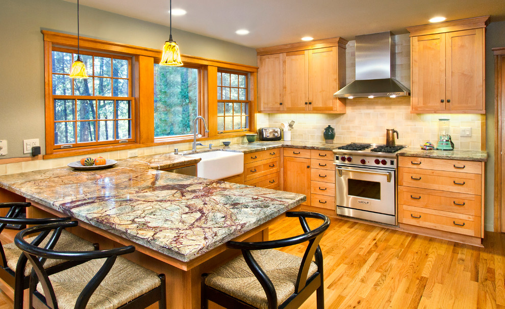 Inspiration for a mid-sized craftsman l-shaped light wood floor and brown floor open concept kitchen remodel in Sacramento with a farmhouse sink, shaker cabinets, light wood cabinets, onyx countertops, beige backsplash, ceramic backsplash, stainless steel appliances and a peninsula