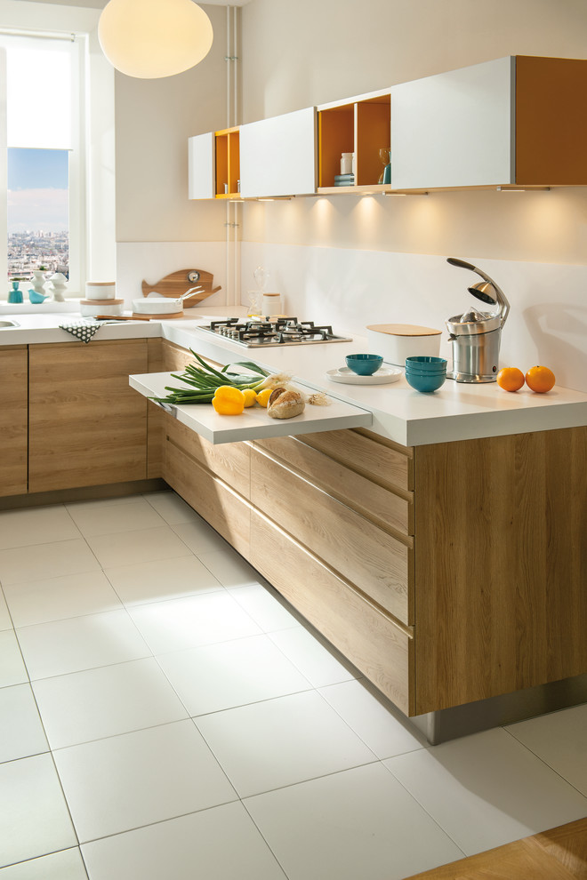 Cette image montre une petite cuisine design en L et bois clair avec un évier 1 bac, une crédence blanche, une crédence en feuille de verre, un électroménager en acier inoxydable et un sol en carrelage de céramique.